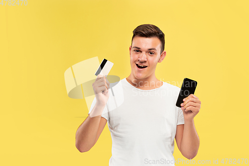 Image of Caucasian young man\'s half-length portrait on yellow background