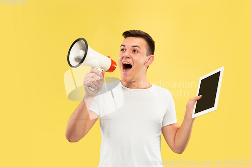 Image of Caucasian young man\'s half-length portrait on yellow background