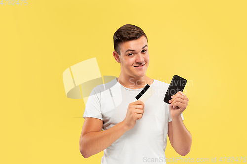 Image of Caucasian young man\'s half-length portrait on yellow background