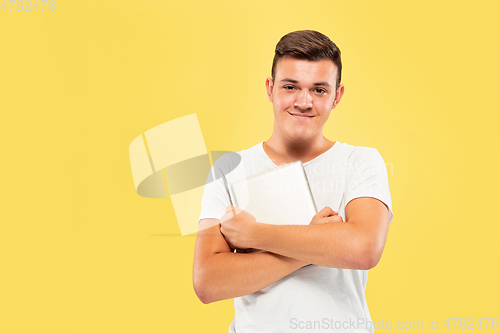 Image of Caucasian young man\'s half-length portrait on yellow background