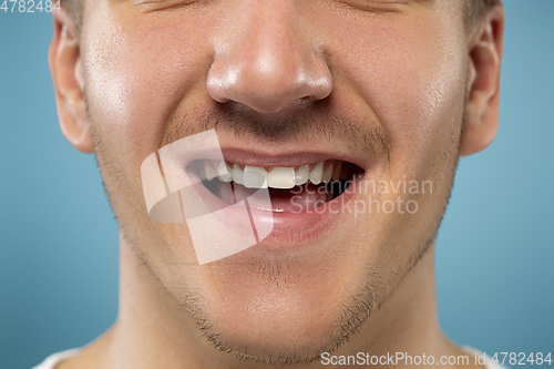 Image of Caucasian young man\'s close up portrait on blue background