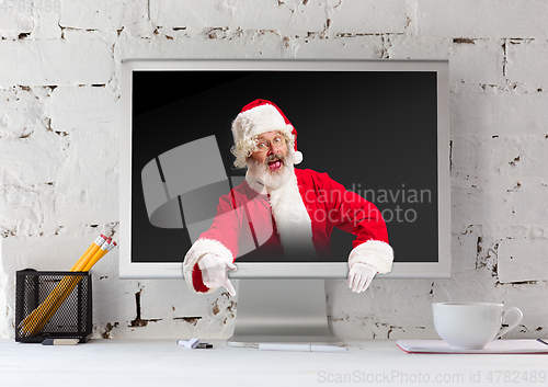 Image of Happy Christmas Santa Claus with monitor