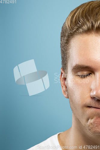 Image of Caucasian young man\'s close up portrait on blue background