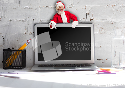 Image of Happy Christmas Santa Claus with laptop