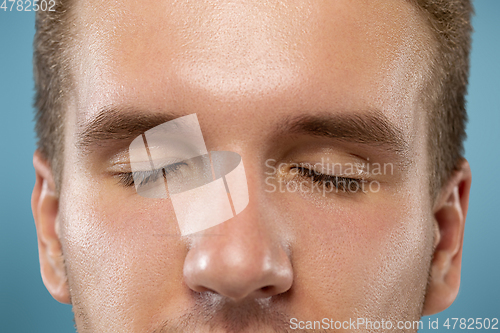 Image of Caucasian young man\'s close up portrait on blue background