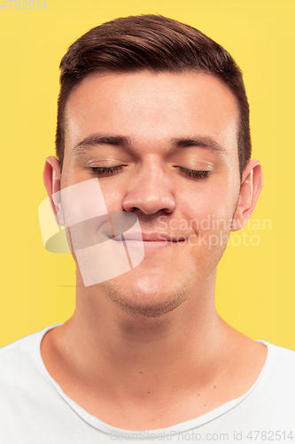 Image of Caucasian young man\'s close up portrait on yellow background