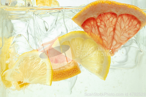 Image of Close up view of the lemon and grapefruit slices in lemonade on background