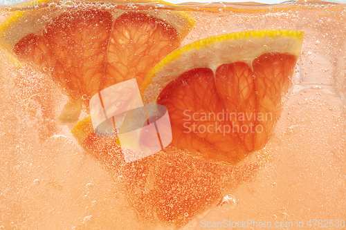 Image of Close up view of the lemon and grapefruit slices in lemonade on background