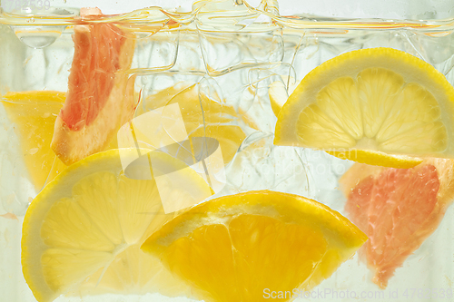 Image of Close up view of the lemon and grapefruit slices in lemonade on background
