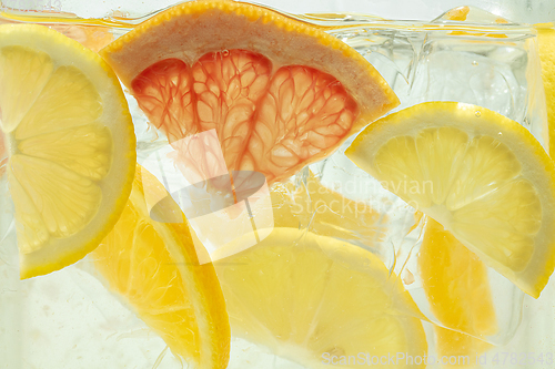 Image of Close up view of the lemon and grapefruit slices in lemonade on background