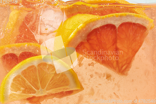 Image of Close up view of the lemon and grapefruit slices in lemonade on background