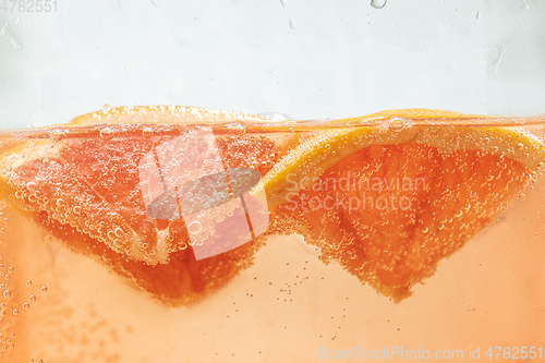 Image of Close up view of the lemon and grapefruit slices in lemonade on background