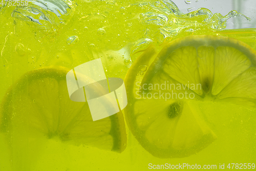 Image of Close up view of the lemon slices in lemonade on background