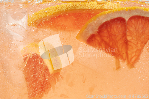 Image of Close up view of the lemon and grapefruit slices in lemonade on background