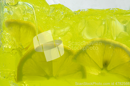 Image of Close up view of the lemon slices in lemonade on background