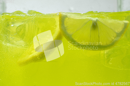 Image of Close up view of the lemon slices in lemonade on background