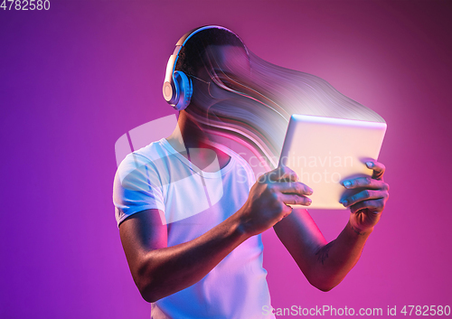 Image of Young man engaged by gadget and social media isolated on purple background