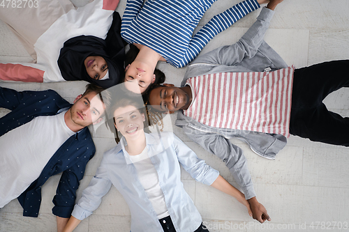 Image of top view of a diverse group of people lying on the floor and symbolizing togetherness