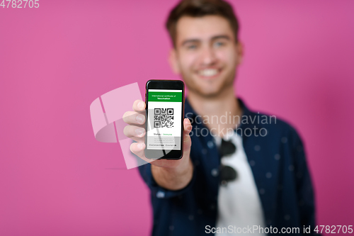 Image of covid passport a young man shows his qr code and covid19 passport on his cell phone