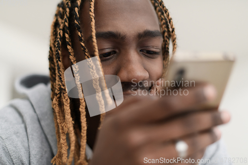 Image of afro guy uses a cell phone and browses social media during a pandemic