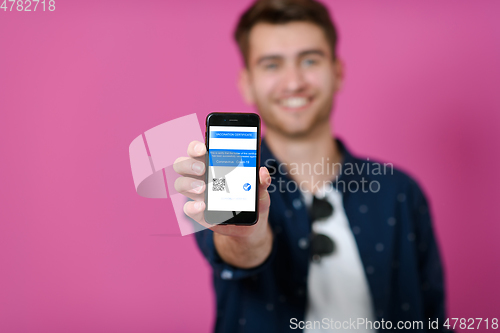 Image of covid passport a young man shows his qr code and covid19 passport on his cell phone