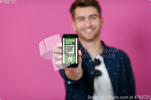 Image of covid passport a young man shows his qr code and covid19 passport on his cell phone