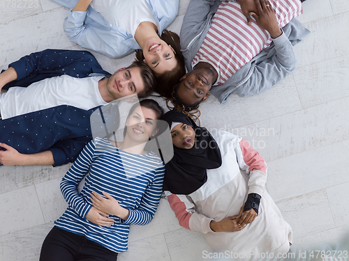 Image of top view of a diverse group of people lying on the floor and symbolizing togetherness