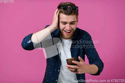 Image of a young man wearing a blue shirt and sunglasses using a smartphone