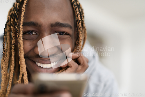 Image of afro guy uses a cell phone and browses social media during a pandemic