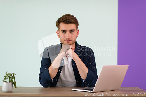 Image of Smiling young man freelancer using laptop studying online working from home