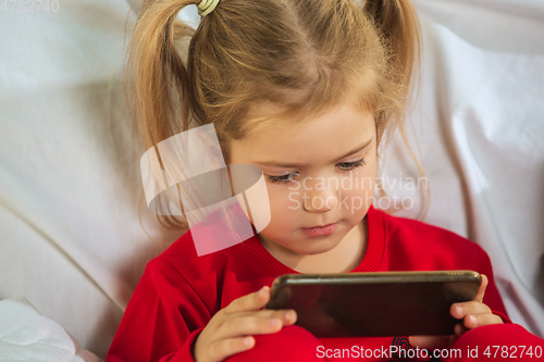 Image of Little girl in soft warm pajama playing at home