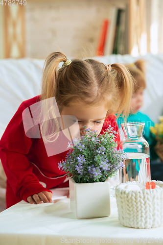 Image of Little girls in soft warm pajamas playing at home