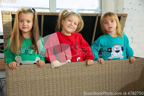 Image of Little girls in soft warm pajamas playing at home