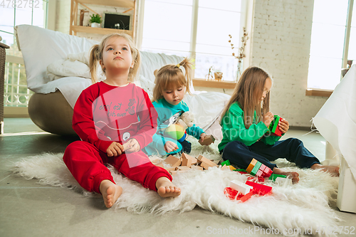 Image of Little girls in soft warm pajamas playing at home