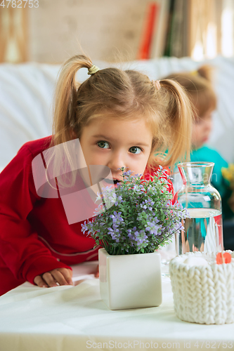 Image of Little girls in soft warm pajamas playing at home