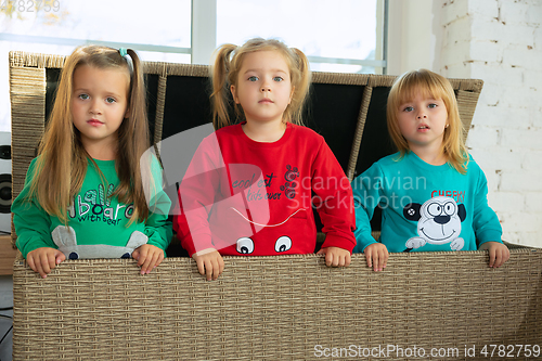 Image of Little girls in soft warm pajamas playing at home