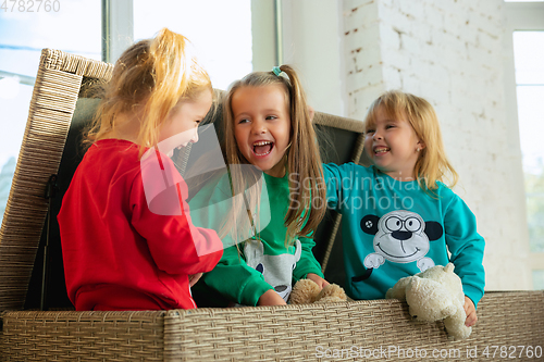 Image of Little girls in soft warm pajamas playing at home