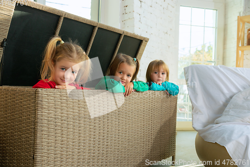 Image of Little girls in soft warm pajamas playing at home