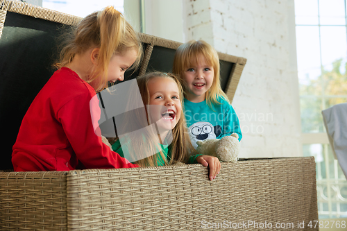 Image of Little girls in soft warm pajamas playing at home