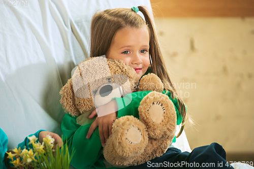 Image of Little girl in soft warm pajama playing at home