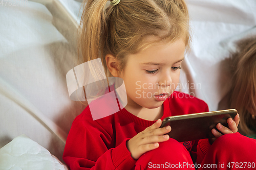 Image of Little girl in soft warm pajama playing at home