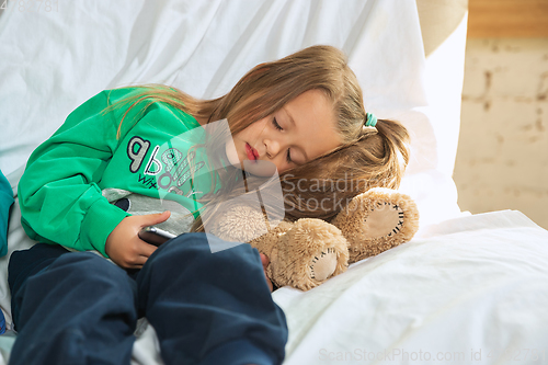 Image of Little girl in soft warm pajama playing at home