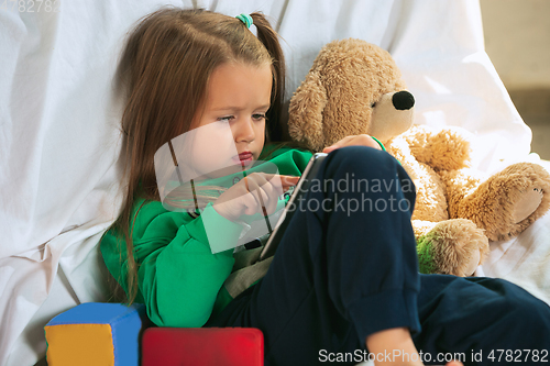 Image of Little girl in soft warm pajama playing at home