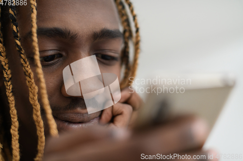 Image of afro guy uses a cell phone and browses social media during a pandemic