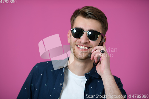 Image of a young man wearing a blue shirt and sunglasses using a smartphone