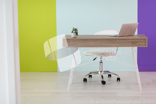 Image of home office concept. chair, laptop, desk and flowers.