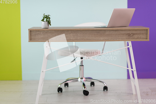 Image of home office concept. chair, laptop, desk and flowers.