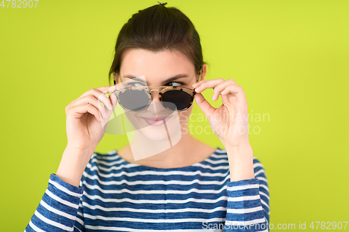 Image of woman in sunglasses posing in front of a green background