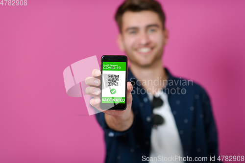 Image of covid passport a young man shows his qr code and covid19 passport on his cell phone