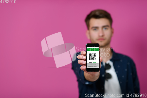 Image of covid passport a young man shows his qr code and covid19 passport on his cell phone